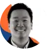 Portrait of a smiling person in a black jacket with a colorful abstract background.