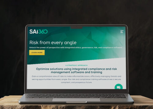 "Laptop displaying a website with the title 'Risk from every angle' on a wooden table"
