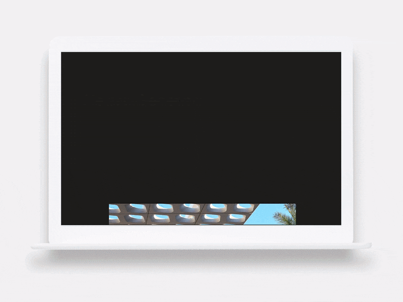 White laptop displaying a website with a minimal design, showing a text headline and a small architectural image.