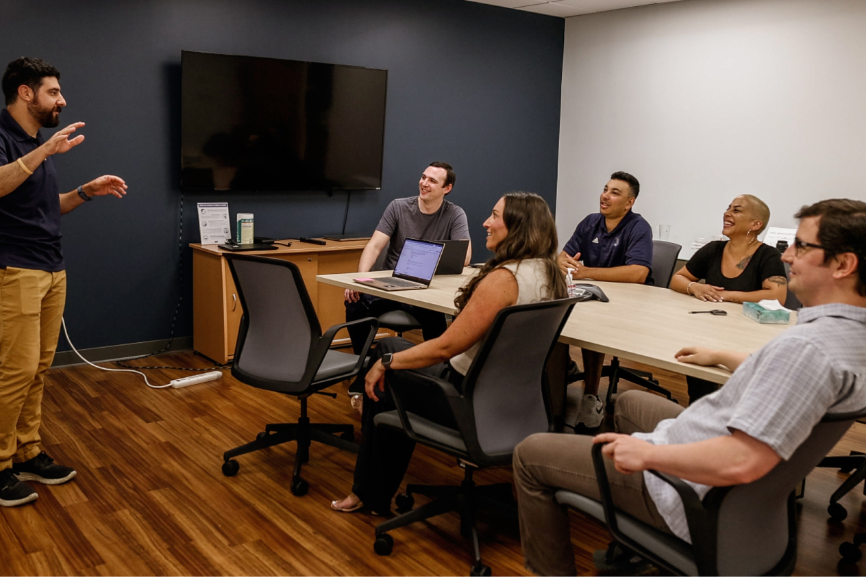 Team members engaged in a discussion during a meeting in a modern conference room.