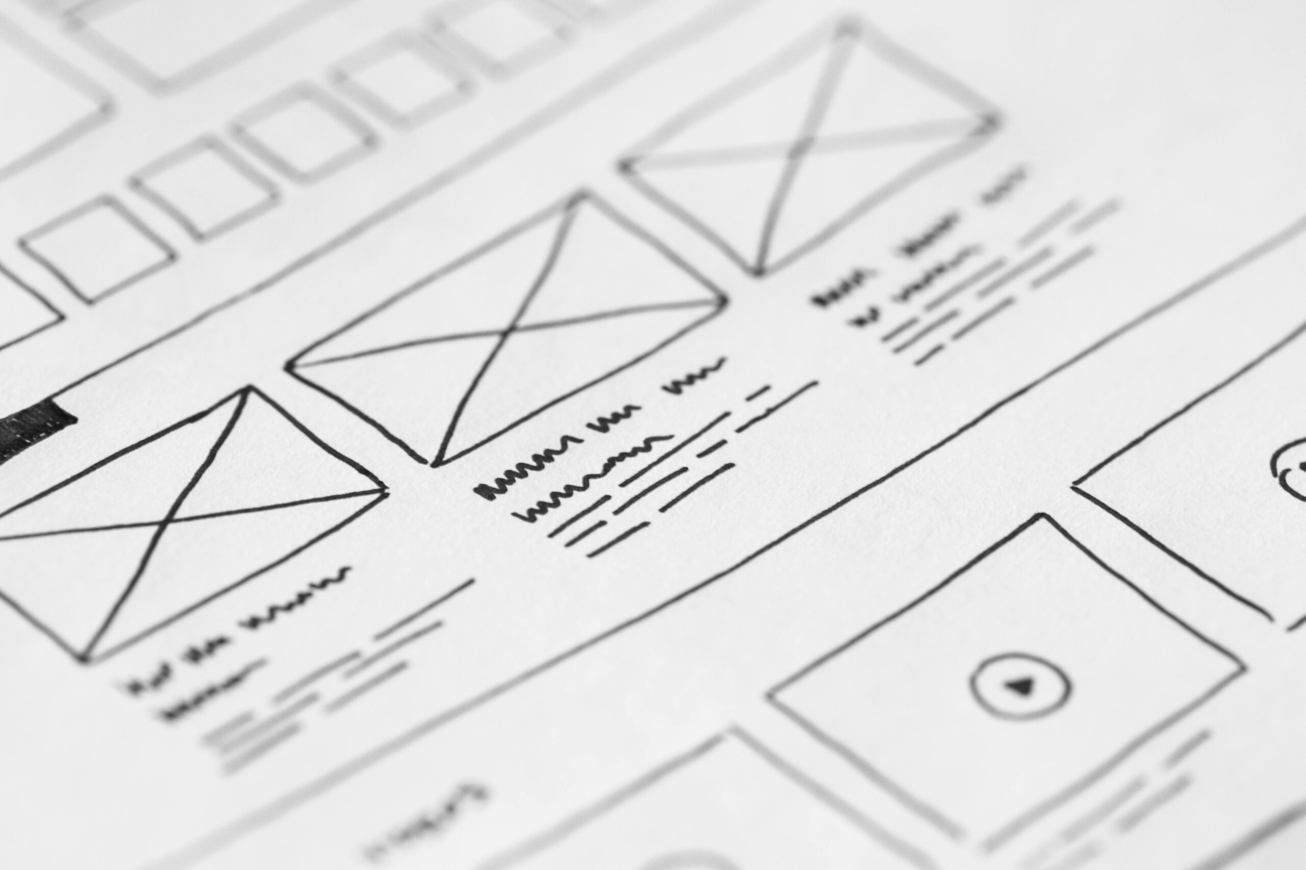 "Wireframe sketch of a website layout with various design elements and placeholders for images and text."
